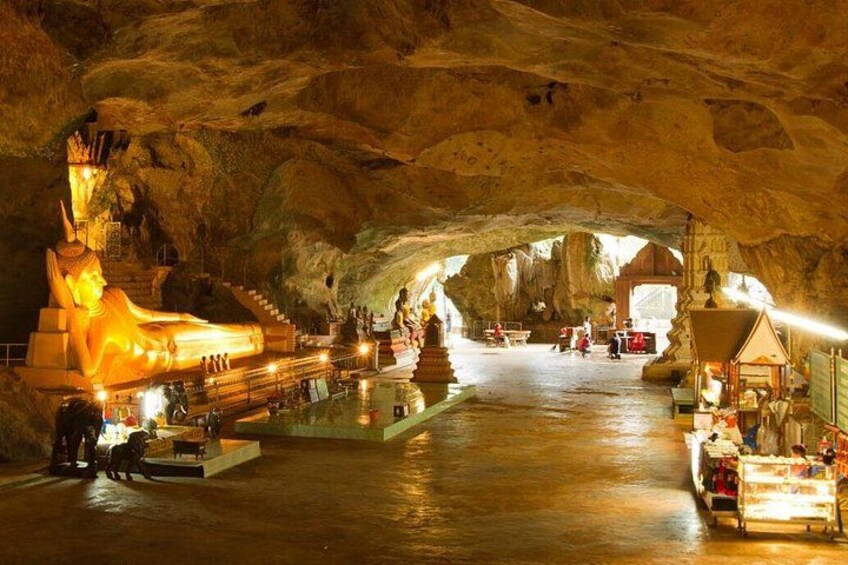 A cave temple with a large Buddha statue, a central pool, and a shrine. 3