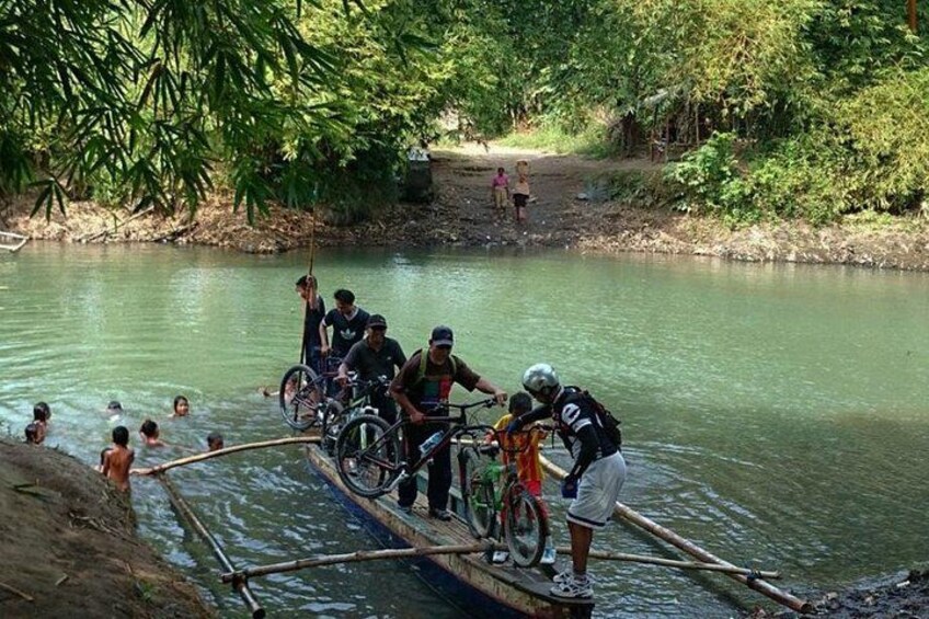 People crossing a river on a makeshift bridge, surrounded by greenery. 4