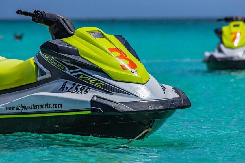 A yellow and black jet ski with the number 3 on its front, floating on turquoise water. 2