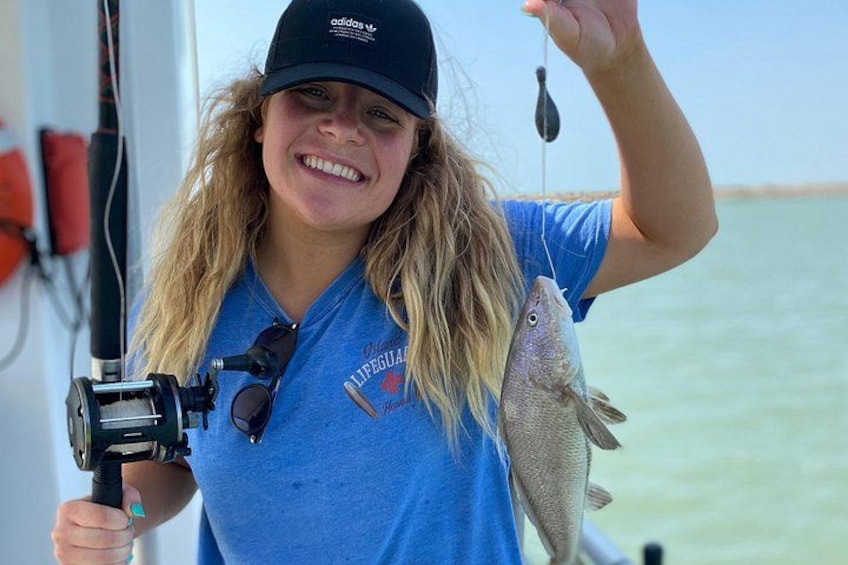 A person holding a fish and a fishing rod. 4