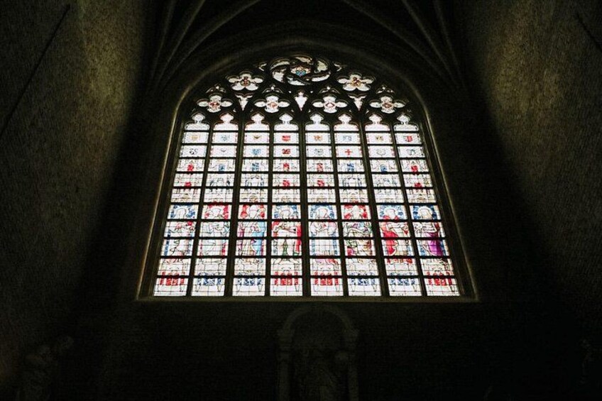 Una ventana de vitral con diseños intrincados y un arco apuntado. 3