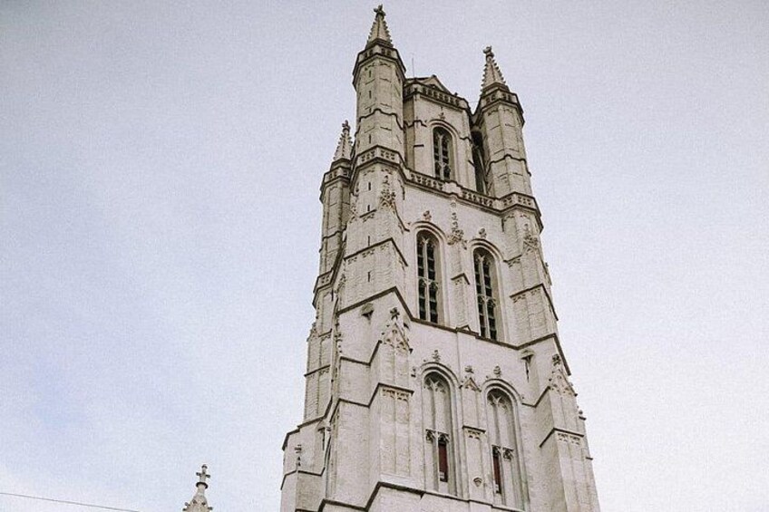 Una alta torre de iglesia de estilo gótico con detalles intrincados en piedra y múltiples agujas. 4