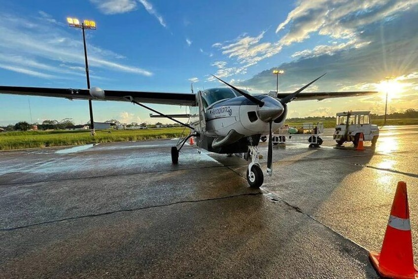 Un piccolo aeromobile su una pista bagnata, con cielo sereno e un tramonto sullo sfondo. 3