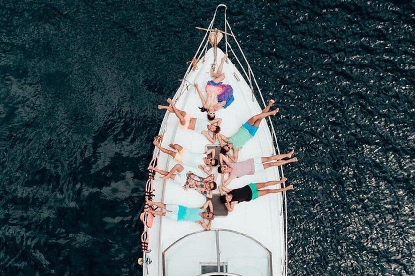 A group of people lying on a boat in the water. 1