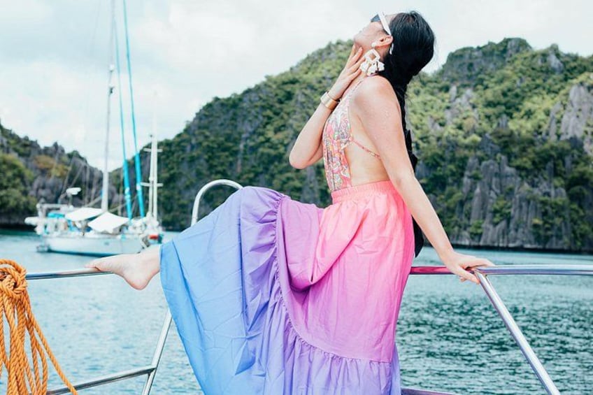 A person on a boat with a mountainous landscape in the background. 5