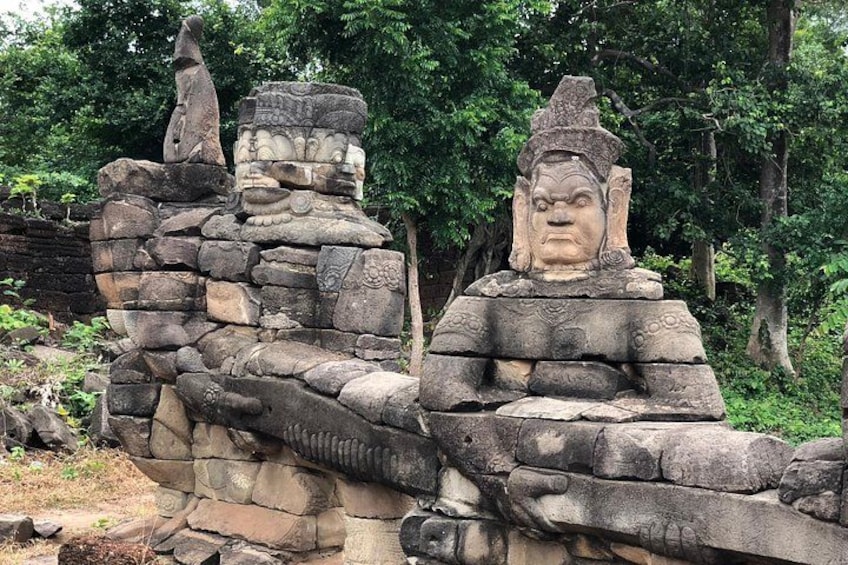 Ancient stone structures with intricate carvings, surrounded by lush greenery. 5