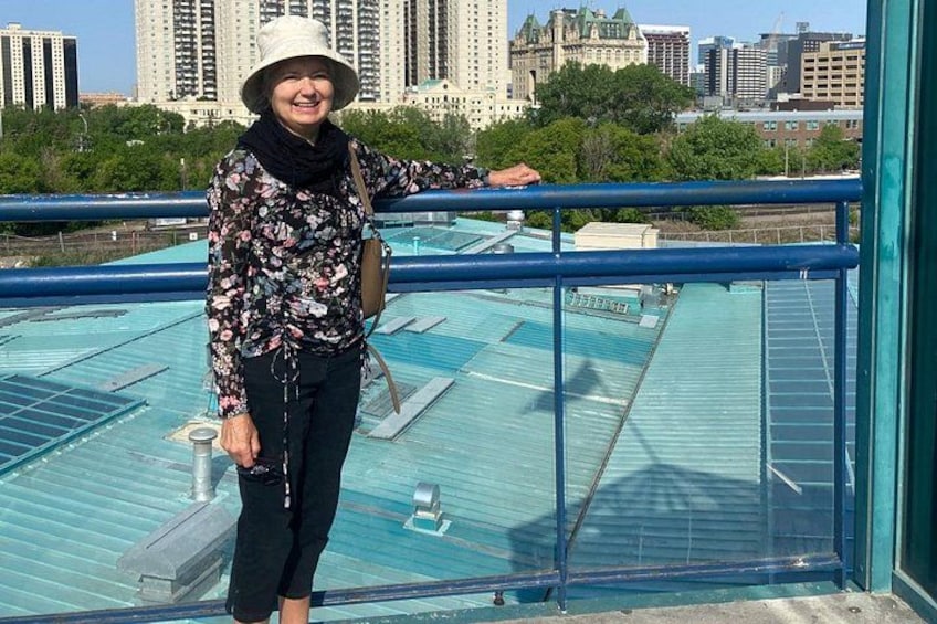 A person standing on a rooftop with a cityscape in the background. 5