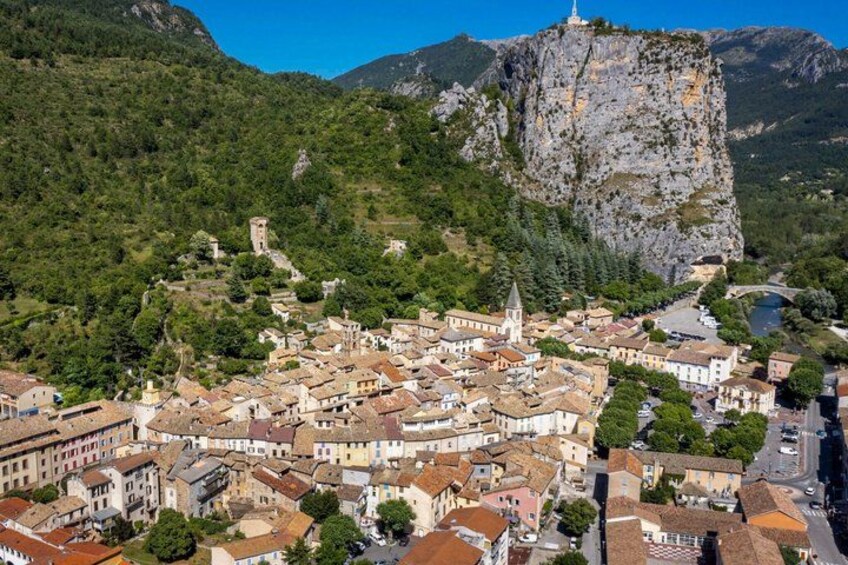 A town nestled in a valley with a prominent rocky cliff and a church. 3