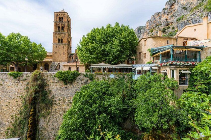 Une ville historique, caractérisée par une tour imposante, une végétation luxuriante et des bâtiments traditionnels. 5