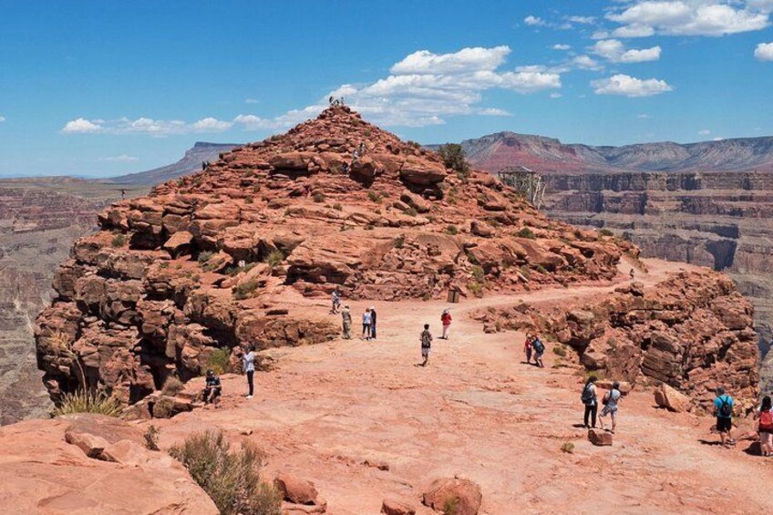 A rocky formation with people hiking around it. 1