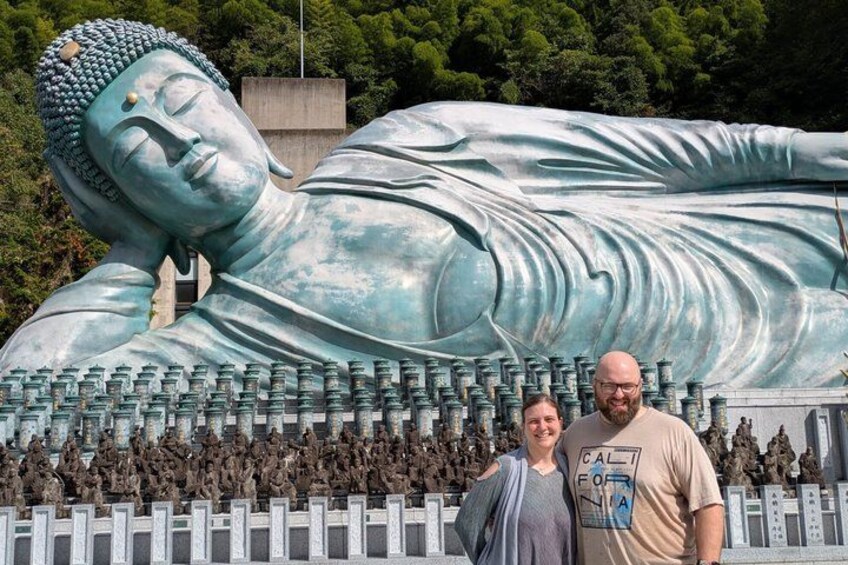 A large reclining Buddha statue with numerous smaller statues in front. 2