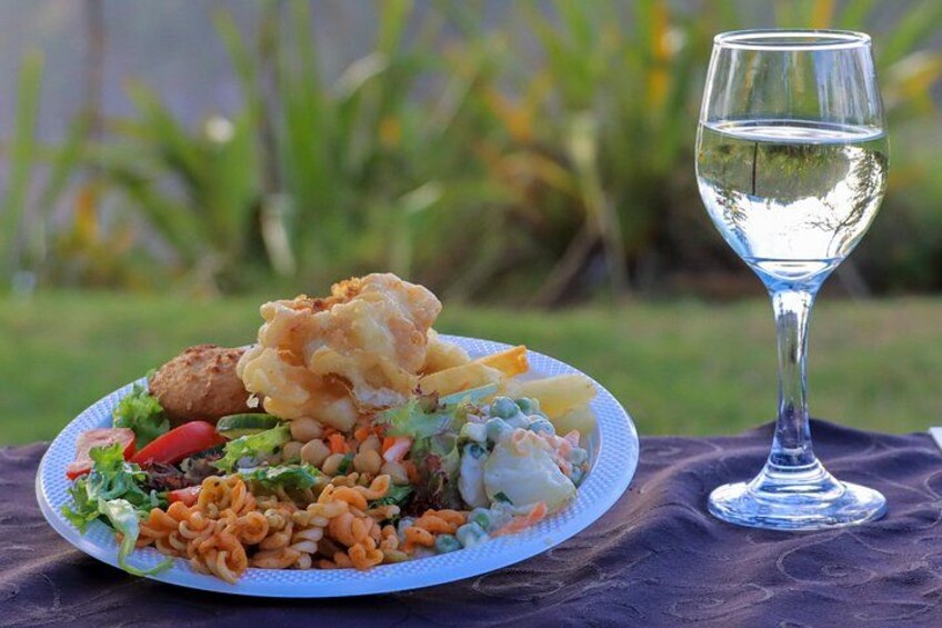 Een bord eten met een glas water op een buitentafel. 1