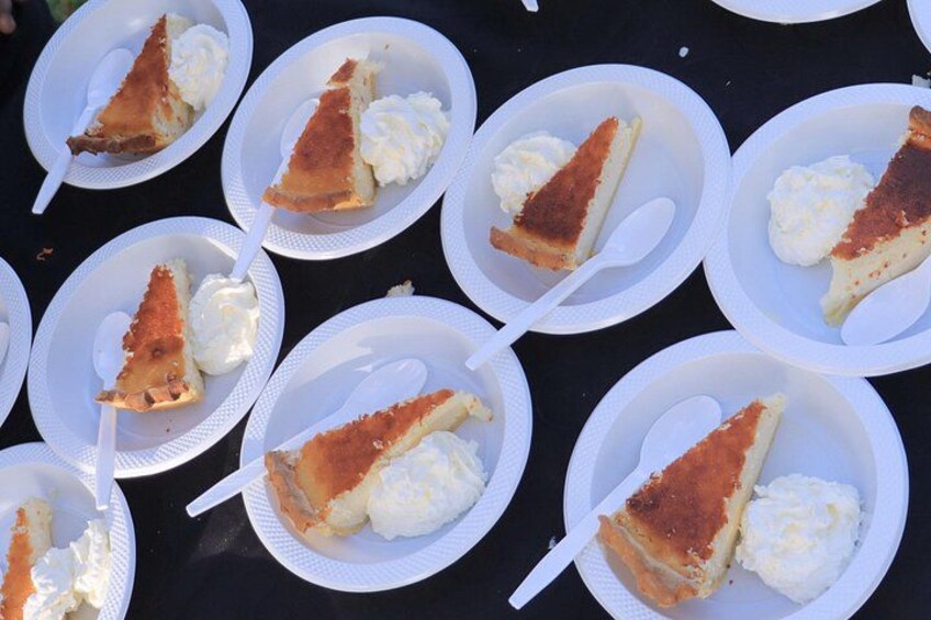 Several white paper plates with slices of pie and whipped cream. 2