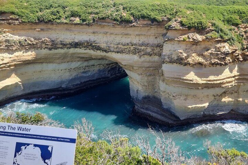A natural rock formation arching over a body of water. 4