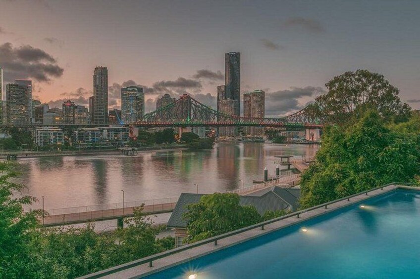 A city skyline with a prominent bridge, a river, and a swimming pool. 2
