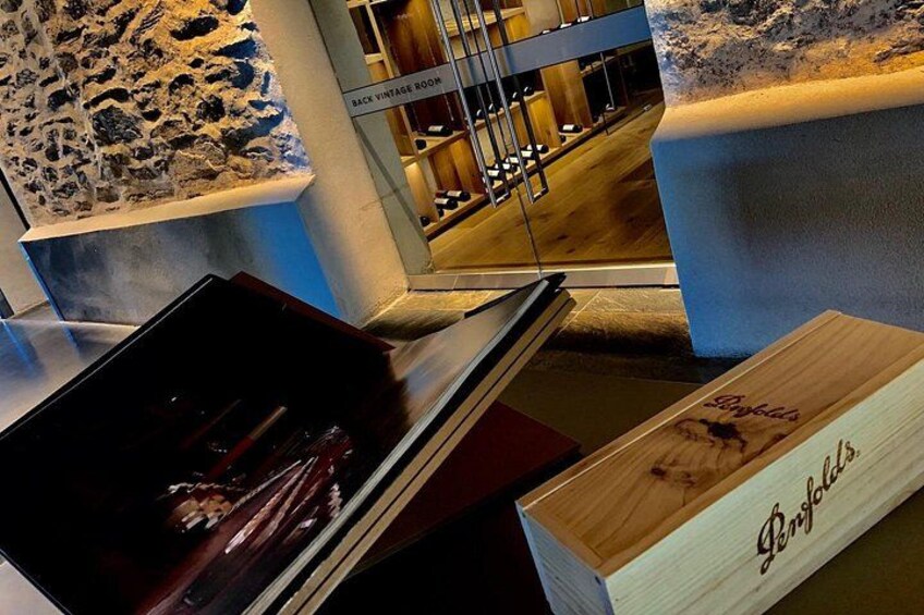 A display of vintage items in a museum with a stone wall and a sign reading 'BACK VINTAGE ROOM'. 3
