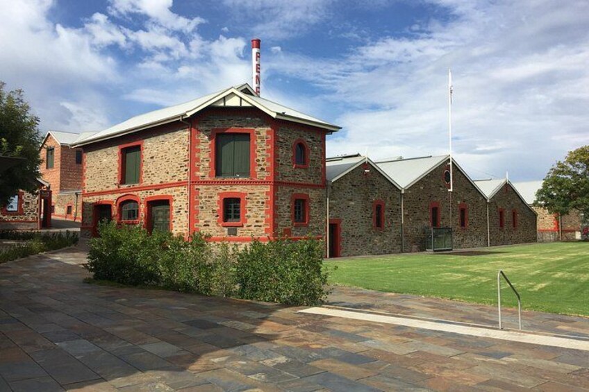 A stone building with red trim, a flagpole, and a well-maintained lawn. 1