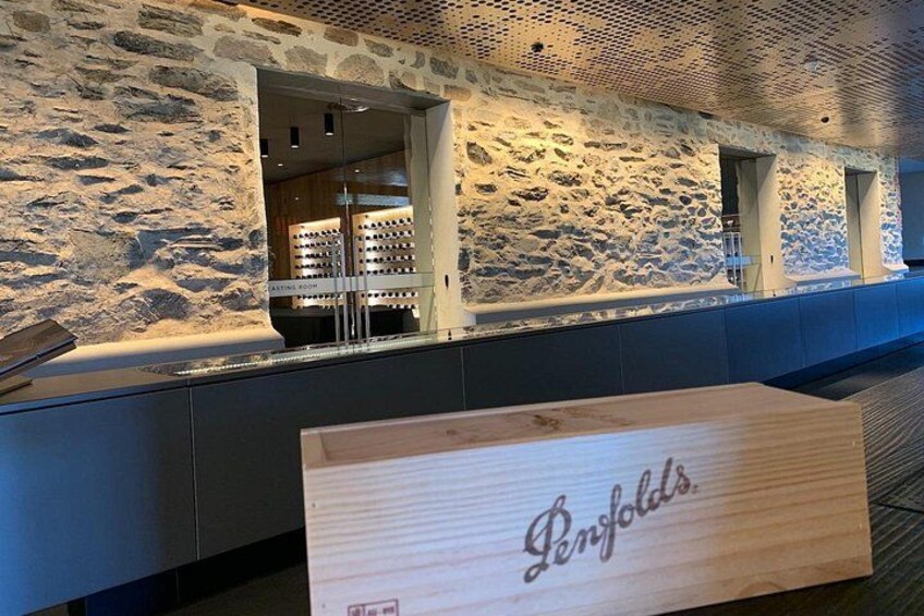 A stone wall interior with a wooden sign reading 'Penfolds.' 4