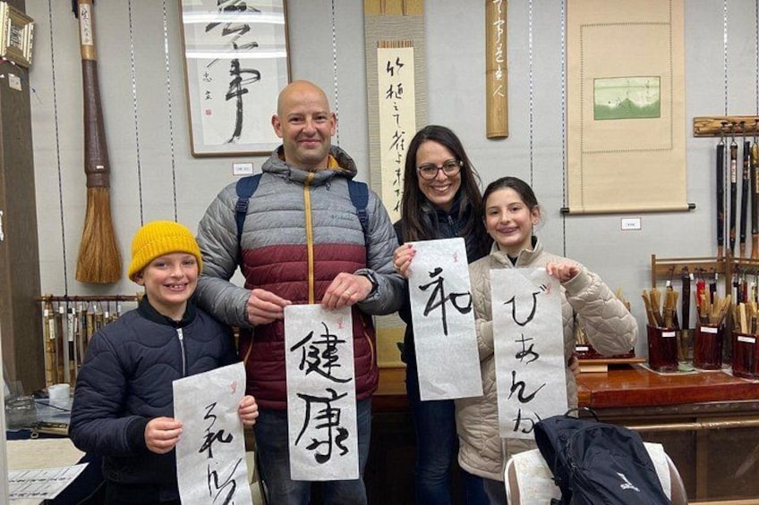 A group of people holding traditional Japanese calligraphy scrolls. 4