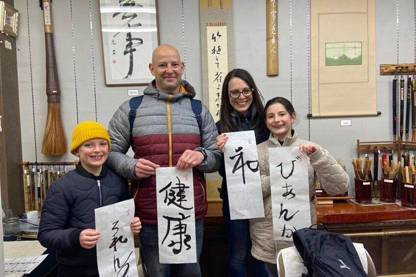 A group of people holding traditional Japanese calligraphy scrolls. 4
