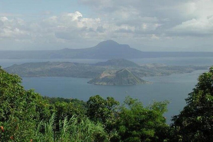 A mountainous landscape with a large body of water and a prominent peak in the distance. 1