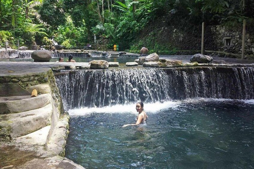 A waterfall, a person in water, and a natural setting with rocks and greenery. 5