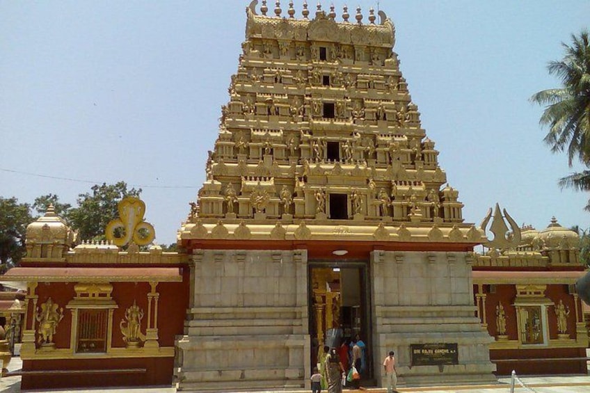 A temple with a tiered gopuram, golden decorations, and a large entrance. 1
