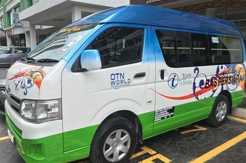 A white and green van with blue accents and colorful graphics, parked in a lot. 4