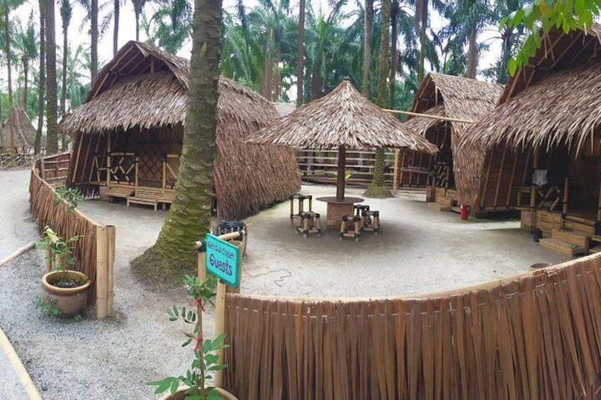 Thatched-roof huts and a sign indicating a guest area. 2