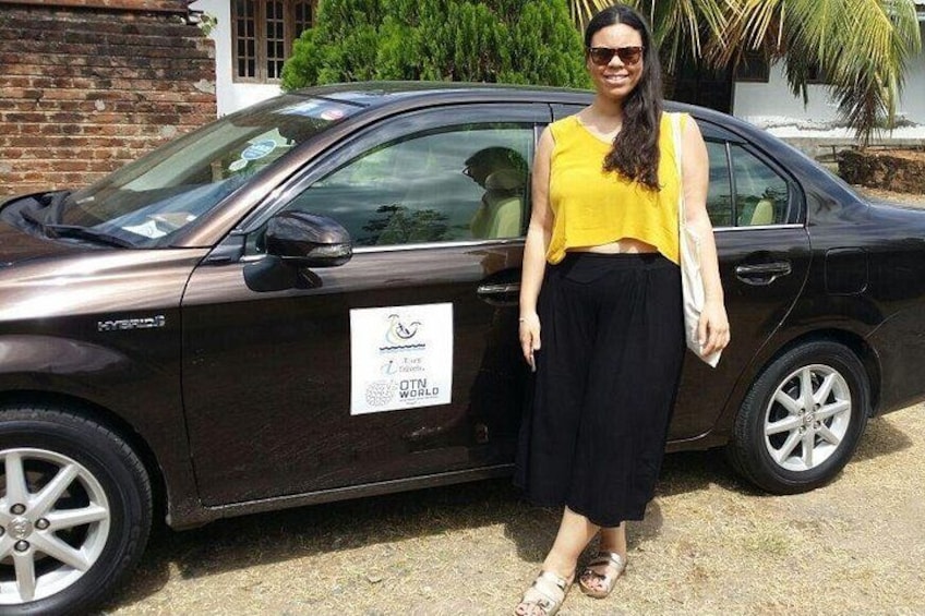 A woman standing next to a car with a sticker on the side. 2