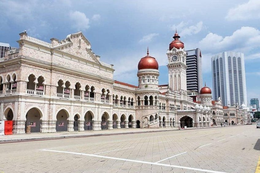 A historic building with domes and a clock tower, surrounded by modern skyscrapers. 2
