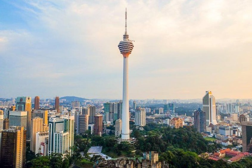 A cityscape with a prominent tower, dense urban buildings, and a mix of greenery. 3