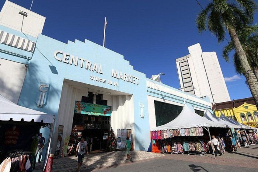 A Central Market building with a blue facade, palm trees, and a clear sky. 5