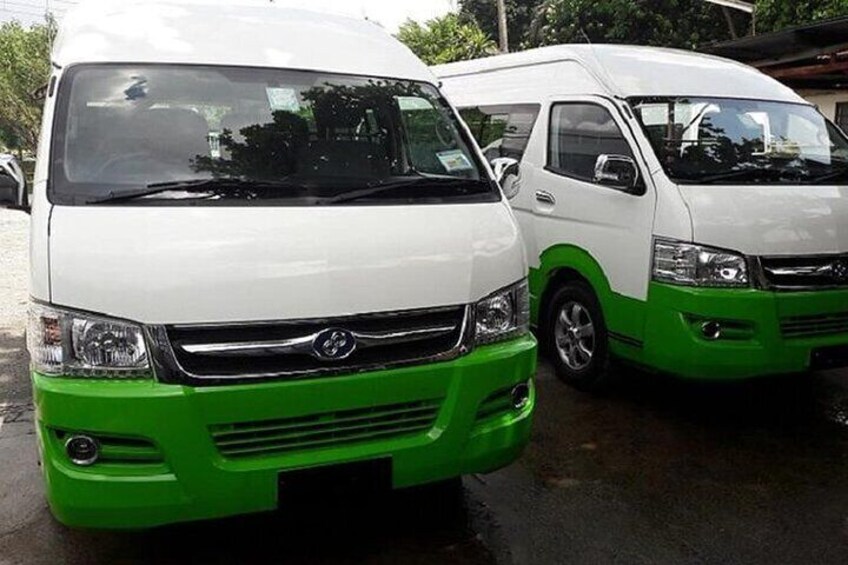 Two white and green vans parked on a wet surface. 5