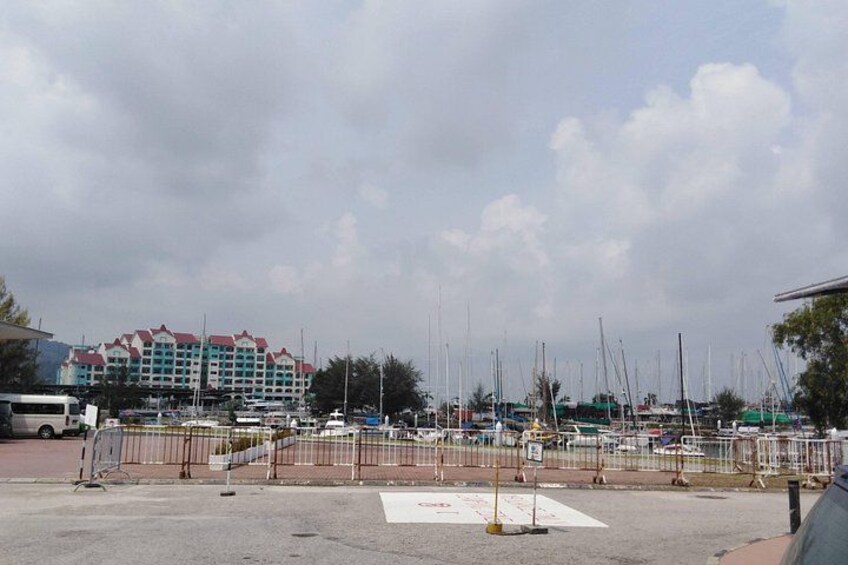 A marina with boats, a hotel, and a cloudy sky. 2