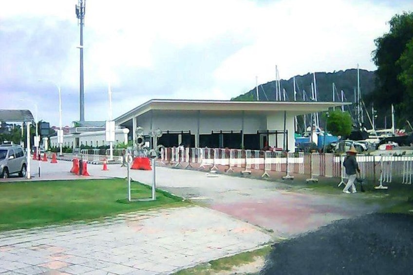 A marina with boats, a covered area, and a pedestrian walkway. 1
