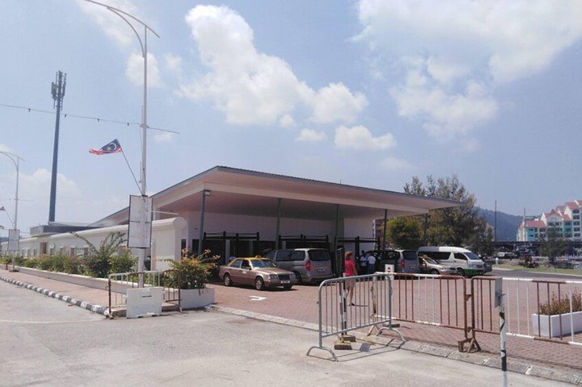 A gas station with a canopy, a flag, and vehicles parked in front. 5