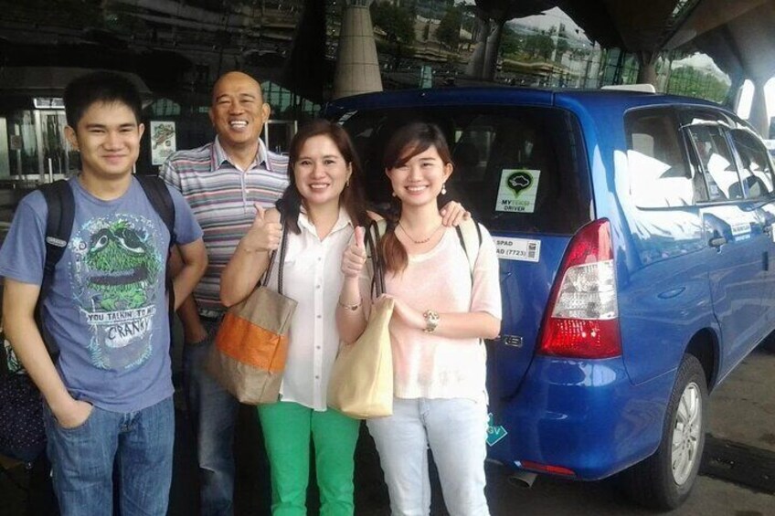 Four people standing in front of a blue van. 5