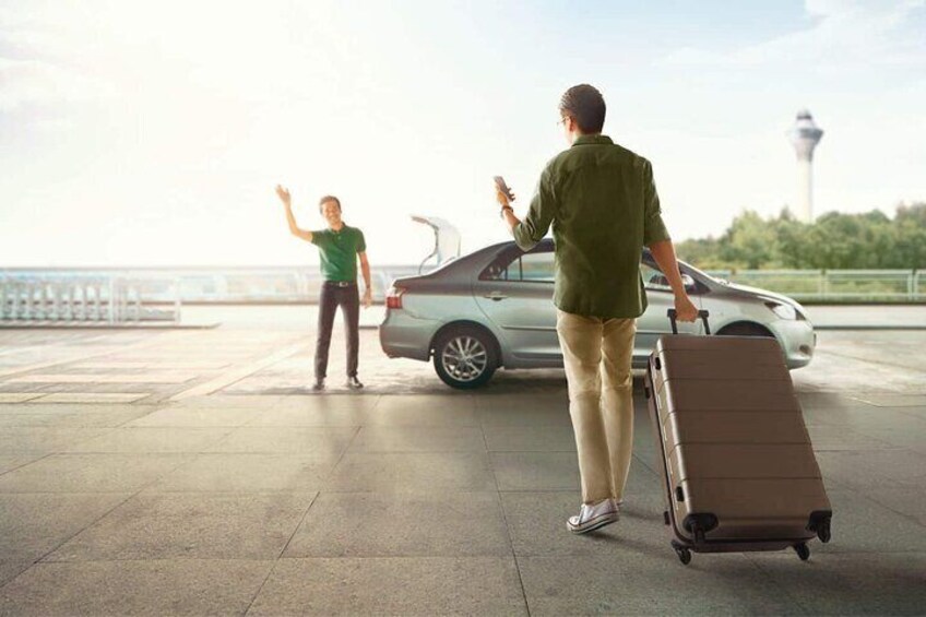 A man with a suitcase walking towards a car, a woman waving, and a tower in the background. 4