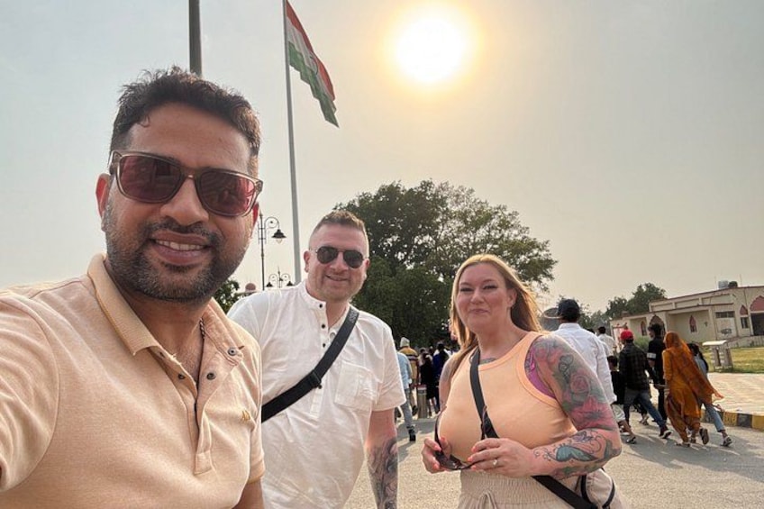 A group of people outdoors with a flag in the background. 3