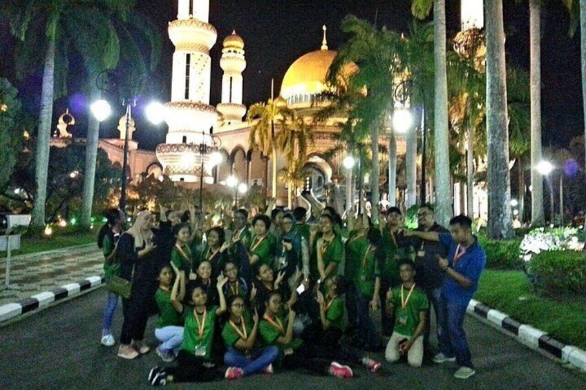 A group of people posing in front of a mosque with a large dome and minarets. 3