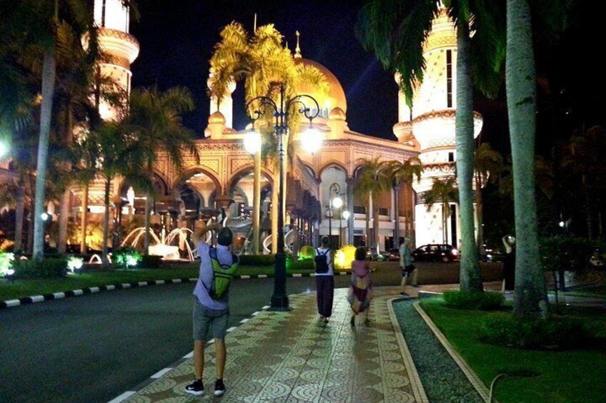 A mosque with a large dome and minarets, palm trees, and a paved walkway. 4