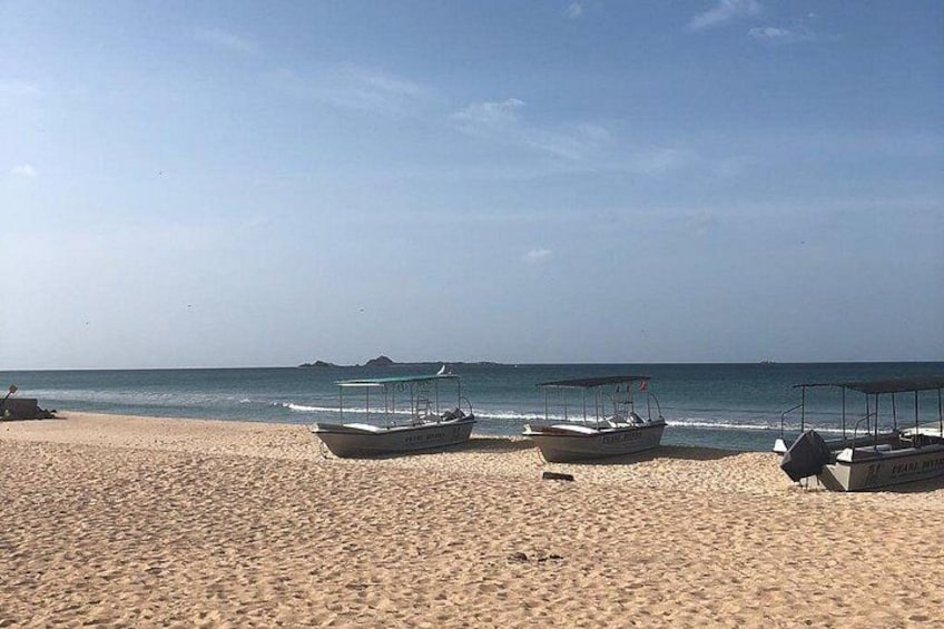 Une plage de sable où plusieurs bateaux sont amarrés près du rivage. 5