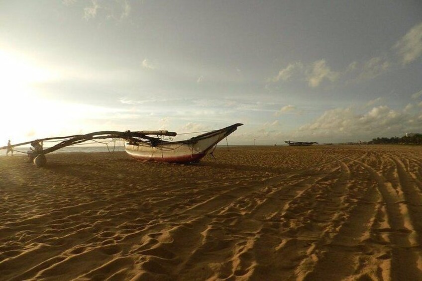 Une plage de sable avec un bateau et une personne au loin. 1