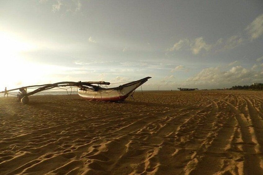 Ein Sandstrand mit einem Boot und einem Flugzeug in der Ferne. 1