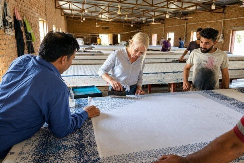 A workshop with people working on large fabric pieces. 2