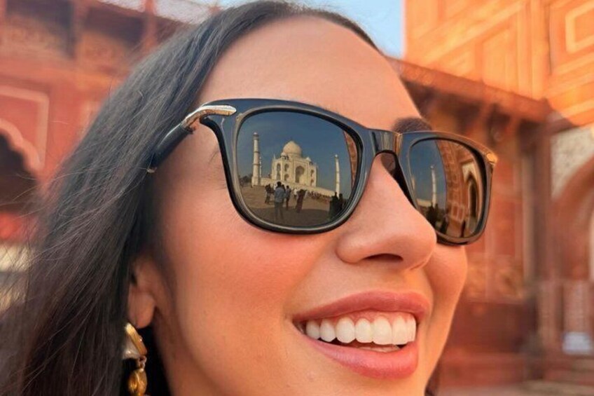 Una persona con gafas de sol, mostrando el reflejo de un edificio en las lentes. 5