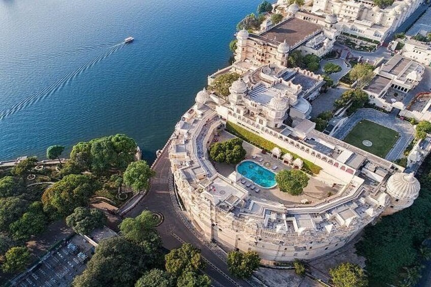 Vista aerea di una tenuta costiera con piscina grande, vegetazione lussureggiante e un tratto d'acqua. 3