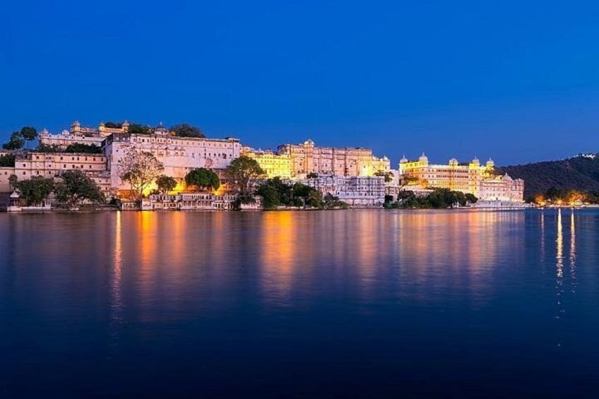 Paesaggio urbano storico con edifici illuminati riflessi nell'acqua al crepuscolo. 1