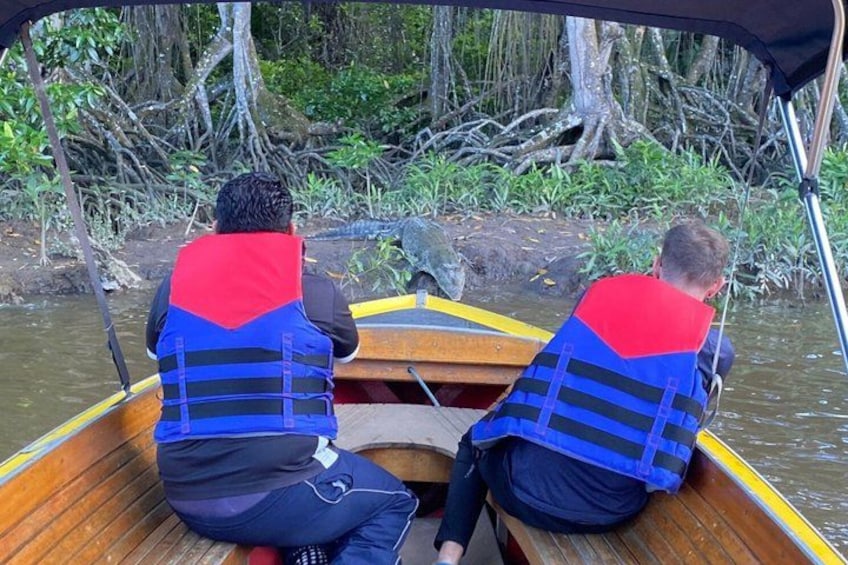 Two people in a boat wearing life jackets, surrounded by water and greenery. 2